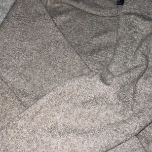 Beige stickad tröja från Vero Moda - Mysig beige stickad tröja från Vero Moda med rund halsringning och ribbade muddar. Perfekt för lager-på-lager och chill dagar. Enkel och stilren design som funkar till allt.