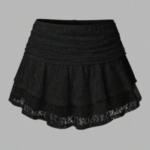 Svart volangkjol i spets🖤 - Supersöt svart kortkjol med dubbla volanger och genombruten spets. Kjolen har hög midja och dragkedja bak. Materialet är spets och kjolen har en lätt utsvängd form.