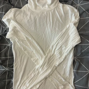 Vit polotröja från lager 157 i storlek S - Vit polotröja från lager 157 i mjukt och tunt material. Tröjan har lång ärm och klassisk hög krage, perfekt att styla med jeans eller kjol. Enkel och clean look som funkar året runt. Tunt material, köpte den för två veckor sen och aldrig använt den.