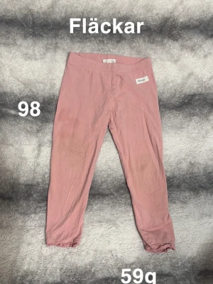 Rosa leggings med spetskant - Säljer ett par rosa leggings från Newbie. Byxorna har elastisk midja och söt spetskant längst ner vid bensluten. Perfekta för en avslappnad och bekväm stil.🌸 Fläckar. Storlek 98