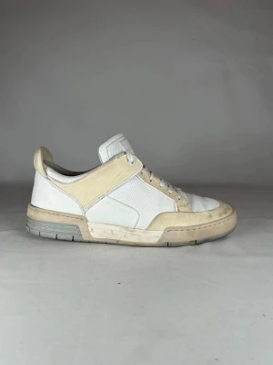 Vita sneakers från Jacob Cohen - Säljer ett par vita sneakers från Jacob Cohen med beige detaljer. Skorna har snörning, rund tå och platt sula. Ovandelen är i en mix av skinn och textil med perforerade partier för extra andningsförmåga. Perfekta för dig som gillar stilrena och klassiska sneakers.