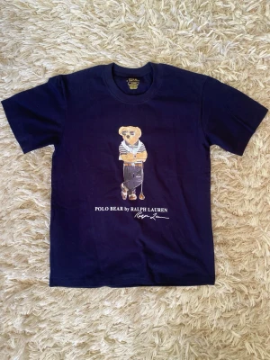 Ralph Lauren polo bear t-shirt - Säljer denna riktigt feta polo bear t-shirt från Ralph Lauren i storlek M och färgen marinblå. Inga tecken på användning och är som ny. Vid andra frågor är det bara komma dm. 