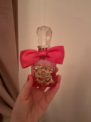 Viva La Juicy Pink Couture - Snygg och trendig parfymflaska med rosa rosett och gulddetaljer. 50 ml Eau de Parfum. Tillverkad i Spanien. Perfekt för dig som vill sticka ut med din stil. Ungefär 50% kvar! Ordinarie pris 500kr