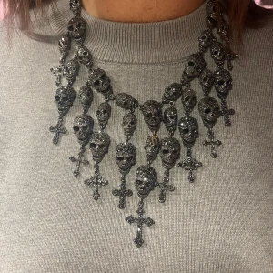 Rock by Sweden - Laila Bagge - Halsbandet är prytt med hela 31 kristallbeklädda döskallar och 11 detaljerade kors, vilket ger en djärv och uttrycksfull look. De gnistrande Stellux-kristallerna är noggrant infattade för att fånga ljuset från alla vinklar och skapa en oemotståndlig lyster. 
