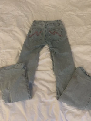 Ljusblå bootcut jeans från Nelly - Ljusblå jeans från Nelly med bootcut passform och slitna hål på båda knäna. Inteals använda så mycket, bra kvalitet 