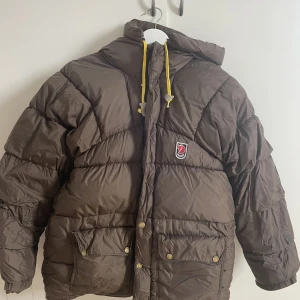 Fjällräven jacka - Säljer min bruna vinterjacka från fjällräven.  Xs-s i storleken.  Den har ett litet hål på ena armen, bild kan fås om de är intressant, därav har jag sänkt priset. De går lätt att åtgärda. 