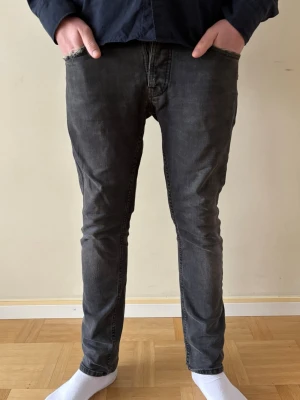 Nudie Jeans - Säljer ett par Nudie Jeans i modellen ”Grim Tim Dark Cove”. Storlek, midja: 30. Längd: 30. Säljes pga för liten storlek. Se defekt på bild 6. Pris kan diskuteras!