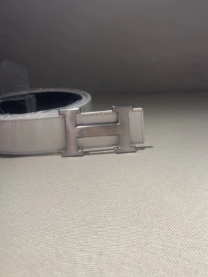 Vit Bälte med H-format spänne – no brand - ✨ Nytt bälte! ✨ 	•	Längd: 110 cm 	•	Finns i vitt & svart ⚪⚫ 	•	Stilrent och praktiskt för alla tillfällen 👌  💖 Köp fler – spara mer! 	•	2 stycken eller fler → rabatt gäller! 🎉