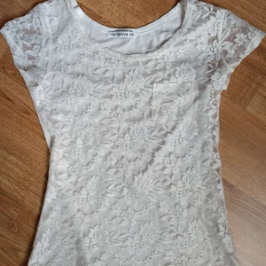 Vit tröja med spets - Har burits 3 gånger och spetsen är i mycket bra skick! Baksidan är av polyester och viskos. En liten gullig ficka sticker fram! 🤍