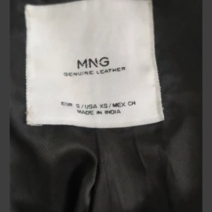 MANGO, svart skinnjacka med nitar.  - Äkta läder, avtagbart bälte, 4 yttre fickor, alla nitar finns kvar men har en lätt skada i häng kroken. 