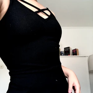 Svart klänning - Svart klänning med medellång kjol, fin snörning där fram. XS Men passar fortfarande mig som är S-M. Väldigt stretchig.