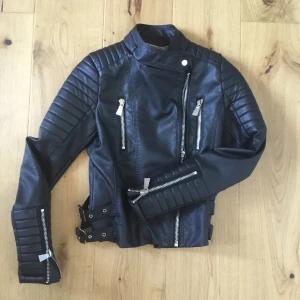 Skinnjacka - Skinnjacka från chiquelle, använd kanske två gånger. Jackan är i toppskick och faktiskt varmare än d flesta skinnjackor. Köpt för 800 kr och säljer för 400. Pris kan diskuteras om ni skriver privat. Storlek 36, ( läderimitation ). 