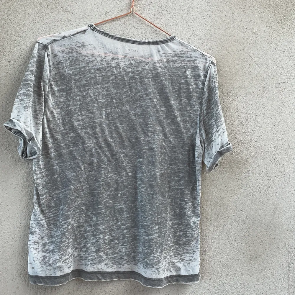 En gråmönstrad t-shirt med tryck på magen. Mycket mjukt material samt fin passform. . T-shirts.
