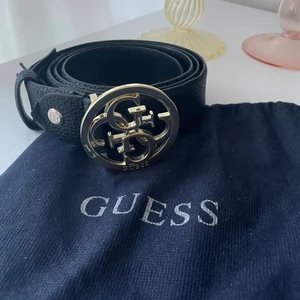 Bälte GUESS - Blälte/skärp från guess. Dustbag ingår. Har gjort egna hål då det var för stort för mig (se bild). Längd ca 115cm