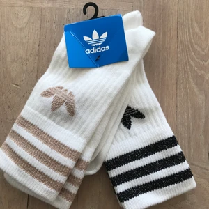Adidas originals strumpor  - Höga strumpor. Ena paret med svart rand och det andra med beige. Båda med glitterdetaljer. Prislapp kvar. 