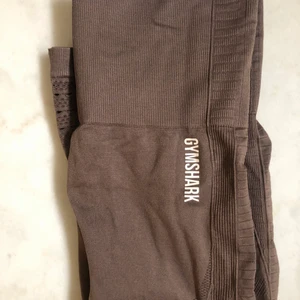 Gymshark leggings  - Ett par croppade bruna leggings från energy seamless kollektionen. Använda ca 1-2 gånger. Inga fel förutom några sprickor i märket som redan brukar framkomma efter 1a tvätten. Köpte för 550