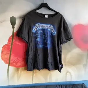 Oversized T-shirt with a Metallica print on, with one sewed in slit at the bottom right
