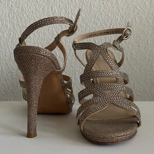 Klackskor glittriga - Klackskor med en lyxig look, perfekta för bal, student, skolavslutning eller om du bara vill skina lite extra. Använda en gång för 3 år sedan och sedan har dem agerat ögongodis på hyllan. Orginal precis var 399kr och köptes på Deichmann. Frakt står man för själv. Hör av dig om du har fler frågor! 