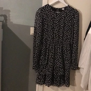 Svart volangklänning - Svart volangklänning från hm med vita blommor. Storlek 36🖤