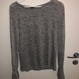 Storlek - M - En grå långärmad tröja med utsvängning vid  handleden i storlek - M
