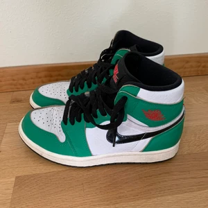Nike Air Jordan 1 lucky green - Skor Nike Air Jordan 1 i fint skick, använda endast tre gånger. Färg grön, svart och vit. Svarta skosnören. Storlek 38. Originalkvitto finns från februari 2021.