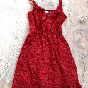 Röd leopard klänning/ storlek 32 - Säljer denna fina omlottklänning med volanger eftersom den inte längre passar💕💕 Den är i gått skick och endast använd 2 gånger.  Köparen står för frakt. Priset är 75kr+66 för frakt.  💗💗🤍