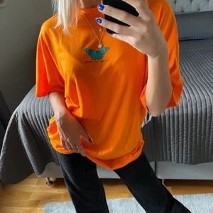 Orange oversized t-shirt strl S - Jättecool, snygg och skön oversized t-shirt i färgen orange. Fjärilen på tröjan är blå/grön/turkos och under den står det ”become the change”! Tröjan är supercool att matcha med ett par baggy byxor eller ett par cykelbyxor, och en snygg keps! Helt oanvänd, så den är i nyskick! Frakt tillkommer. 