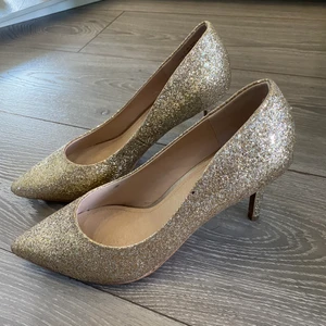 Guld klackskor - Nya glitter guld klackskor. Oanvända fortfarande i paket och i bra skick. Storlek 39/40. 