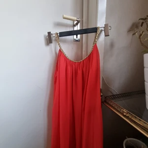 Koralröd klänning - Vintage klänning i färg av koralröd med flätad guldkant. Perfekt nu till julen eller bara en fin sommarkväll! Klänningen passar XS/S/M eftersom att passformen är mer "fri".