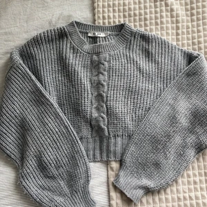 Kabelstickad cropped tröja  - Sååå fin cropped kabelstickad tröja från NAKD! Andra bilden är tröjan från hemsidan, min är dock i mörkgrå som inte säljs i den färgen mer 🧡 nypris 299:-, väldigt sparsamt använd och superfint skick!
