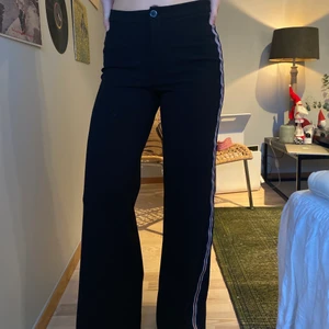 Utsvängda svarta byxor i Stl XS - Säljer ett par stretchiga byxor med rand på båda sidorna. Färg: svarta stl: 34 skick: begagnad orginalpris: 499kr 