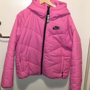 Jacka  - En rosa vinterjacka från Nike med luva och fickor. Varm och använd sparsamt så den är i väldigt bra skick. Kortare i modellen. 