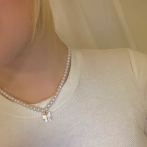 Pärlhalsband med vitfjäril🦋 - Egengjort pärlhalsband med vit fjäril🤍 Justerbarlängd med knäppe⚪️ Köparen står för frakten