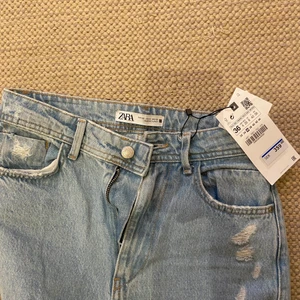 Jeans med slitning längst ner - Oanvända jeans från Zara med prislapp, köpte i somras stlk 36. Dom har slitningar nedtill och är lite bagy. Jag kan dessvärre inte ta bild på då dom är för små. Köpta för 359kr, säljer för 100kr +66kr (spårbar frakt).