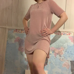 Rosa glittrig klänning - Rosa glittrig klänning som är lite som en oversized T-shirt💖 Väldigt fin men kommer tyvärr inte till användning💖 Skickar med frimärken för att försöka få ner fraktkostnad💖