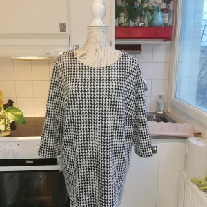 Tunika från XLNT i storlek XL, knappt använd - Snygg tunika från XLNT i storlek XL som i princip aldrig blivit använd utan bara fått lika i garderoben. Väldigt snygg både till jobb och till kvällen i hundtandsmönster. 
