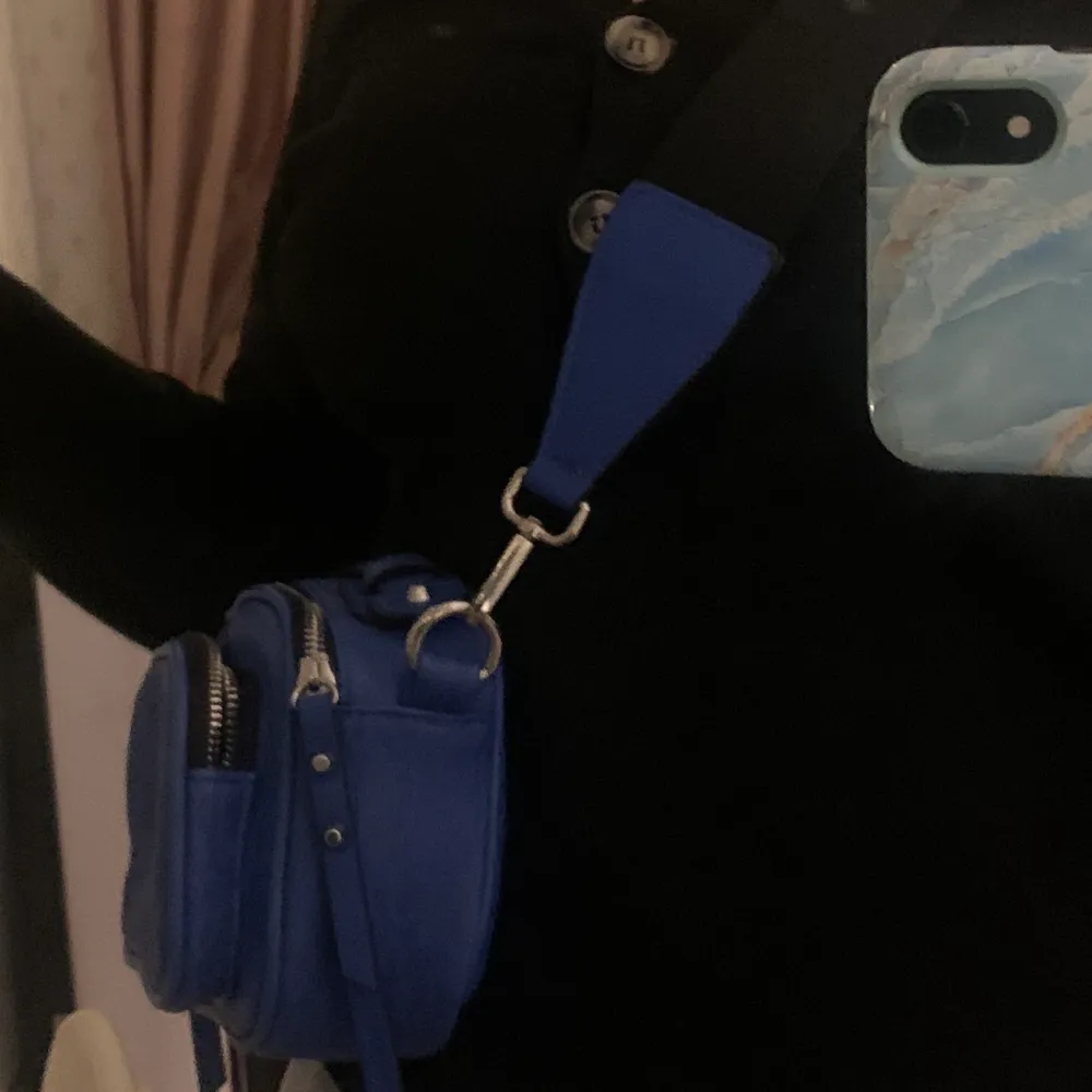 Säljer denna jättefina blåa väskan då jag aldrig har hittat ett tillfälle att använda den🦋 Med väskan kommer ett justerbart band. Nyskick!. Väskor.