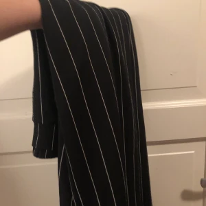 Svarta vitrandiga byxor straight leg - Riktigt sköna och luftiga byxor i straight leg-modell. Jag som är 175 tycker de sitter bra på mig men de kan klippas för att passa någon kortare om man it vill att de ska vara ”baggy” vid fötterna. Hör av dig om du vill ha bilder på eller mer info!🌟🌟