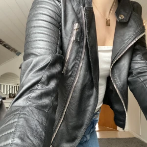 Chiquelle Skinnjacka - Säljer den typiska chiquelle skinnjackan (moto jacket black) i läderimitation. Inga skråmor förutom att knappen upptill i kragen har lossnat(se bild 3). Ord.pris 699kr. Mitt pris: 100kr Köparen står för frakt. 