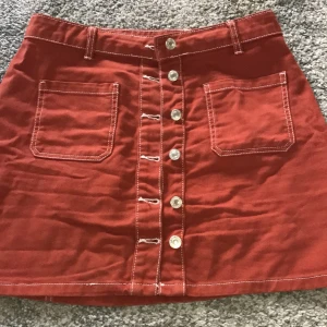 Röd denimkjol m knappar o kontrastsömmar - Så himla fin röd denimkjol inköpt i Tyskland med två söta fickor, knappar hela vägen och kontrastsömmar 🤤