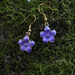 Örhängen Blåsippa - Handgjorda örhängen med guldpläterad berlock och nickelfria krokar 🌸 Berlocken är cirka 1,5 centimeter i diameter. Det finns också ett tillhörande halsband att köpa till, nytt pris för set: 100kr ✨ Örhängena levereras i en fin liten presentpåse. Frakt på 13kr tillkommer 🌞