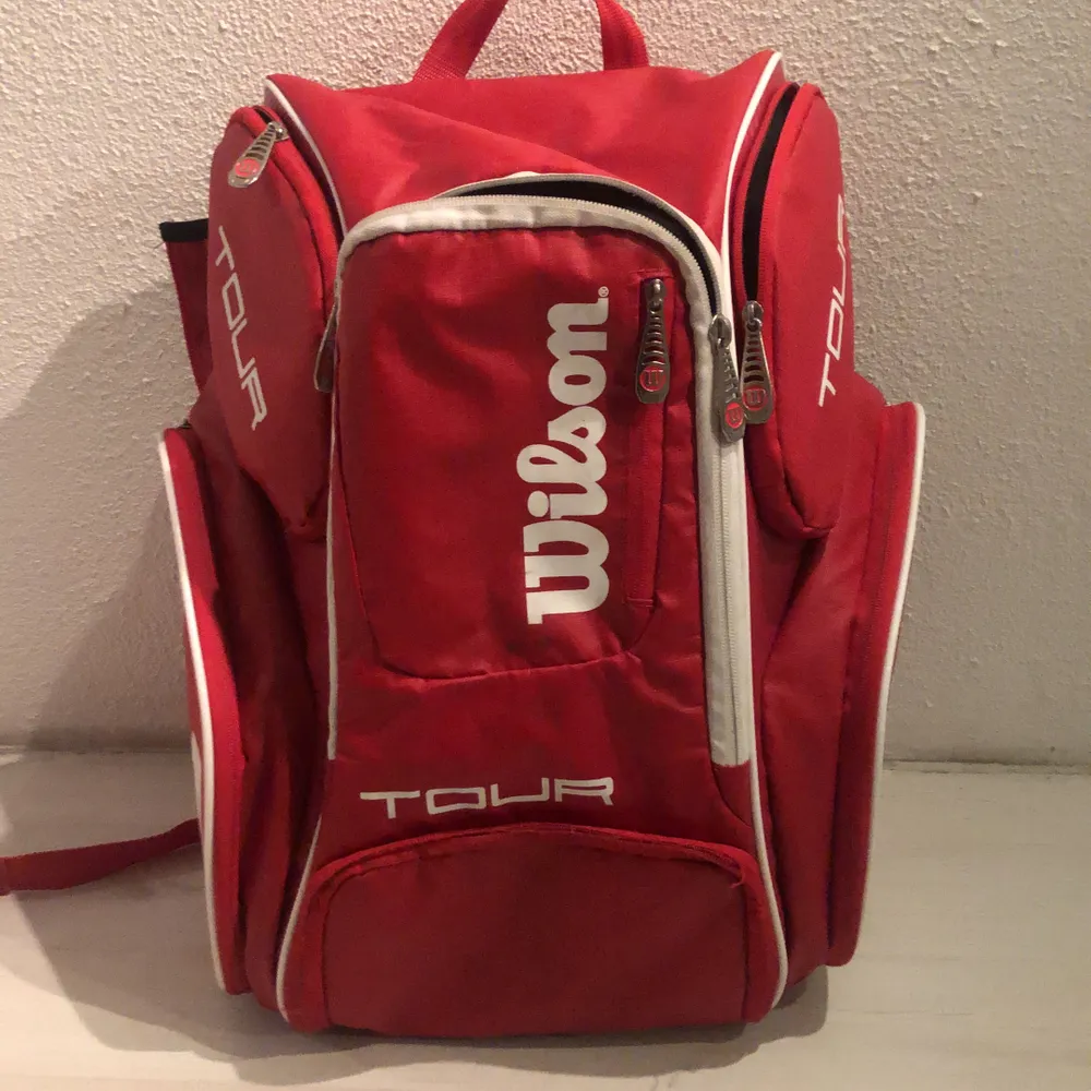 En röd wilson tennis väska med 8 fack. Säljer eftersom har köpt en större och ett annat märke.. Väskor.