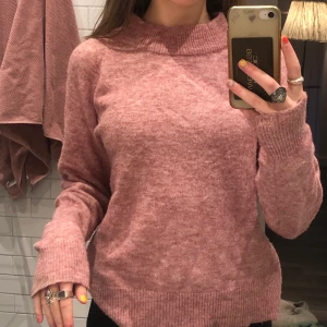 Rosa stickad tröja st xs - Detta är en rosa stickad tröja som har tjocka muddar vid halsen och på slutet av ärmen. 