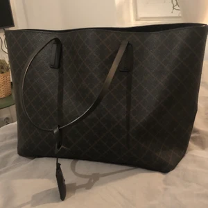 By Malene Birger väska  - Det här är en By Malene Birger Abigail Bag som är i färgen Dark Chokolate. Den är 48 x 28 x 12,5 cm stor. Jag köpte den på Debut för 2299kr.                            Det är bara att buda i kommentarerna och budgivningen börjar på 500kr