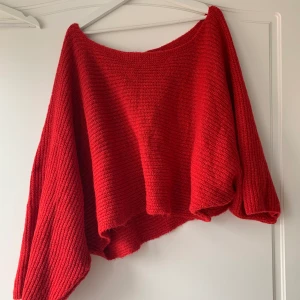 Röd stickad tröja  - Fin stickad tröja som är oversized och tanken att man ska ha oneshoulder. Bra skick och sparsamt använd. Köpt på NAKD från Trendyol. I storlek s.