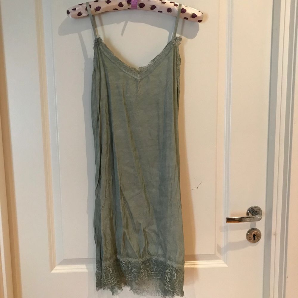Green silk top/tunic/dress looks and feels like silk, decorated with very beautiful lace at the top and bottom. 61% rayon, 39% viscosa. Made in Italy. Köparen står för frakten. . Toppar.