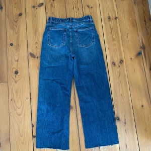 H&M - Fina mörkare jeans som är vida i benen i strl 38 från H&M. Rökfritt hem. Är lite korta på mig som är 170 lång och bär storlek 38 i byxor. 