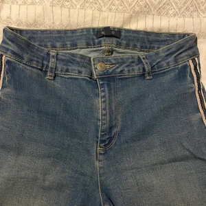 Jeans - Ett par skinny jeans som har blå/vita sträck på sidorna. Mycket bra skick på byxorna då jag endast använt de 1-2 gånger. Är storlek 36 men kan även passa 38 då de är stretchiga. Kontakta vid frågor eller intresse💕