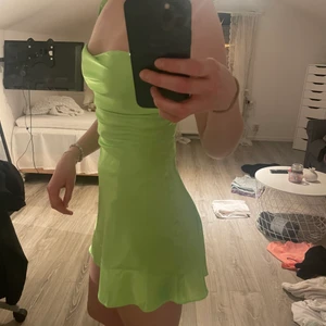 Limegrön klänning i silke  - Kort oanvänd klänning i silke, jag är ca 170cm lång, är på gränsen till förliten