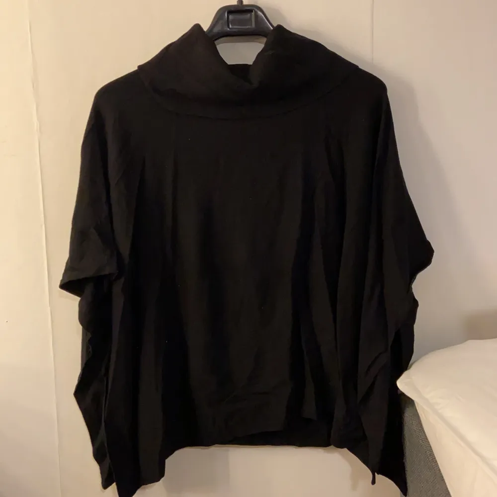 En svart poncholiknande tröja i ett mjukt tyg. . Tröjor & Koftor.